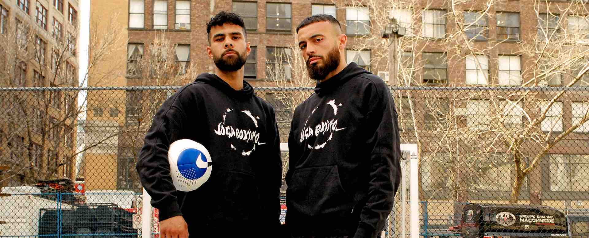 Two-young-men-wearing-soccer-apparel-with-a-soccer-ball-in-hand.